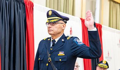 The new chief raises his right hand to be sworn in.